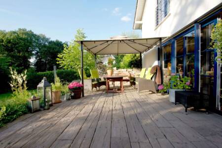 Modern angelegte Terrasse mit Holzbelag und Sitzmöbeln im Außenbereich