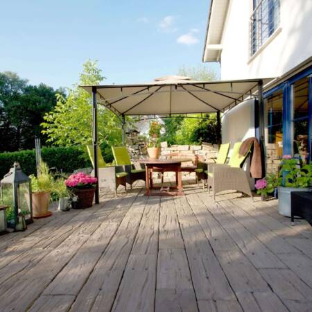 Modern angelegte Terrasse mit Holzbelag und Sitzmöbeln im Außenbereich