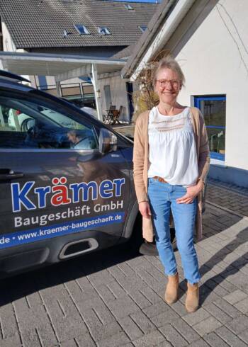 Barbara Renfordt, kaufmännische Angestellte beim Baugeschäft Krämer, vor Firmenfahrzeug stehend